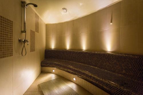 凯尔采Qubus酒店的浴室设有淋浴和长凳,配有灯