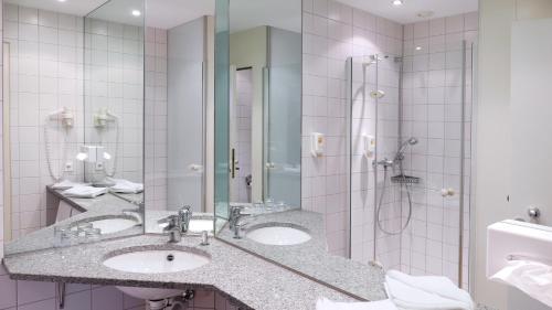费尔德基希卢文中心酒店的一间带两个盥洗盆和淋浴的浴室