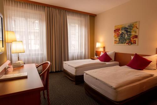 费尔德基希卢文中心酒店的酒店客房配有两张床和一张书桌