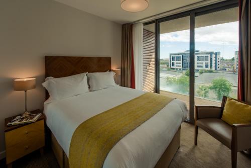 桑迪福德PREMIER SUITES Dublin, Sandyford的一间设有大床和窗户的酒店客房