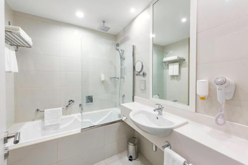 拉斯阿尔卡麦Citymax Hotel Ras Al Khaimah的白色的浴室设有水槽和浴缸。