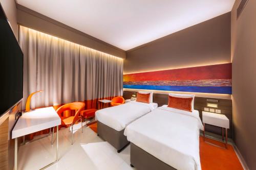 拉斯阿尔卡麦Citymax Hotel Ras Al Khaimah的酒店客房配有两张床和一张书桌