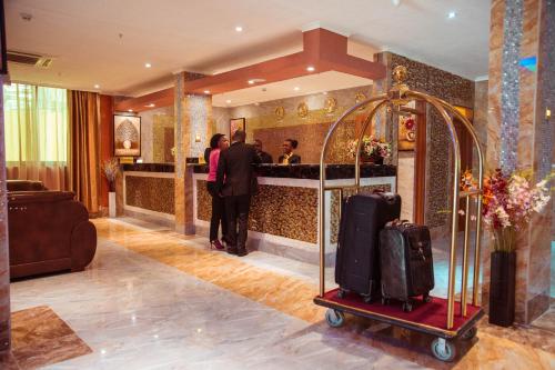 达累斯萨拉姆Tiffany Diamond Hotels LTD - Makunganya的大堂在酒吧前设有行李车