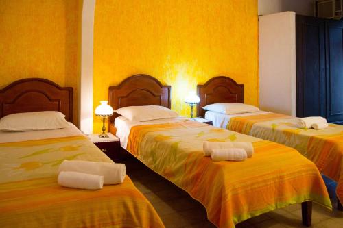 埃斯特城Hotel & Restaurante Guarania的酒店客房,配有三张床和毛巾