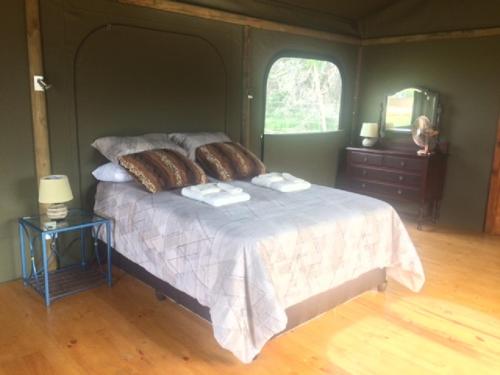 普利登堡湾Hillcrest Lodge Tents - Sandstone的一间卧室配有一张床,上面有两条毛巾