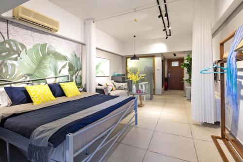 三亚三亚市三亚湾区·三亚湾旅游区·路客精品公寓·00164300的一间卧室配有黄色和蓝色枕头的床