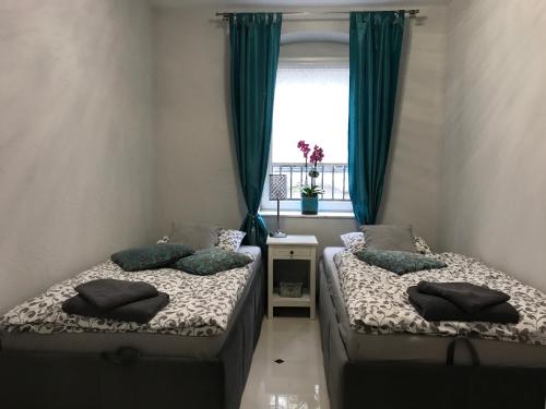 波兹南Marii Konopnickiej 20的配有绿窗帘和窗户的客房内的两张床