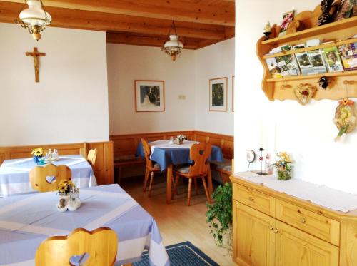 Schönau im Mühlkreis费瑞恩霍夫克瑞埃鲍莫尔乡村民宿的餐厅设有两张桌子,墙上有十字架