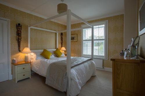 切尔滕纳姆Number 8 Cheltenham的一间卧室配有一张带天蓬的白色床
