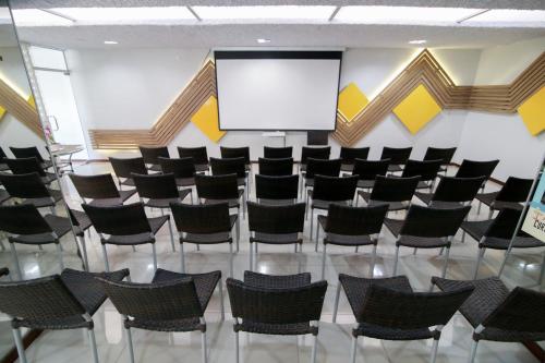 马塞约阿古阿斯首府旅馆的一个带椅子和屏幕的会议室