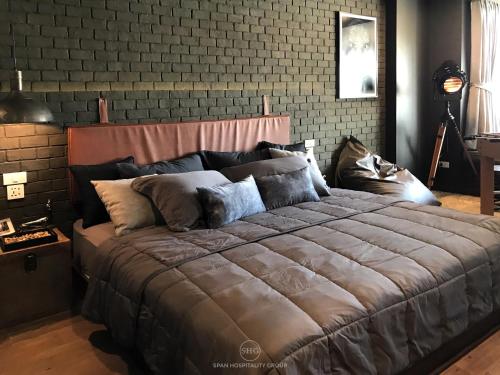 清迈Stay in Style at Nimman R911的砖墙客房内的一张大床