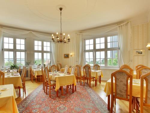 汉堡丹姆特帕拉兹贝尔莫酒店的一间带桌椅和吊灯的用餐室
