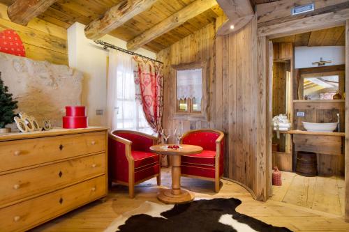 NembiaChalet Sogno di Fiaba的一间房间,配有红色椅子和一张桌子