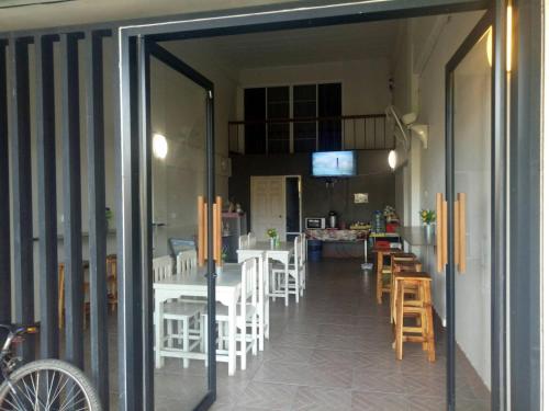 清莱TT Hostel Chiangrai的通往带桌椅的用餐室的开放式门