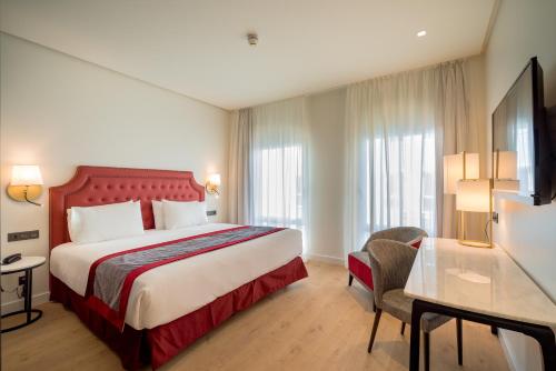 科尔多瓦Eurostars Azahar的配有一张床和一张书桌的酒店客房