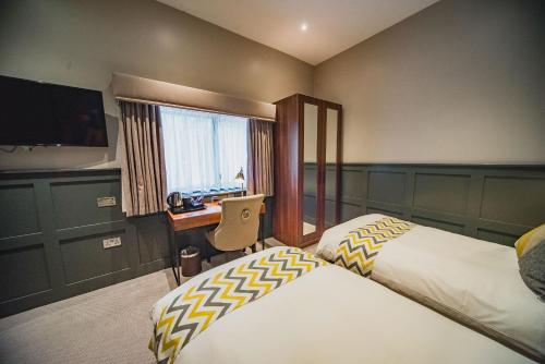 根斯堡Thonock Park B&B的酒店客房设有两张床、一张桌子和一台电视。