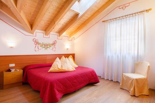 莫尔韦诺Casa Nonni的一间卧室配有红色的床和椅子