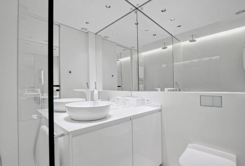 波兹南Andersia Park的白色的浴室设有两个盥洗盆和镜子