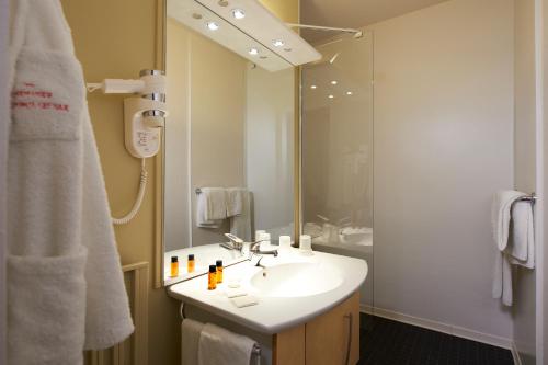 达克斯大酒店的浴室配有盥洗盆和带镜子的淋浴