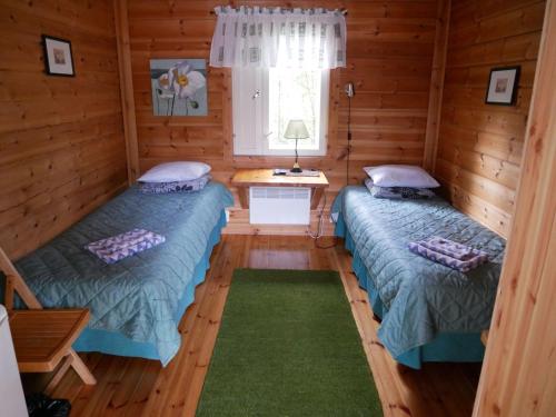 拉彭兰塔Guesthouse Miekkala的小木屋内的两张床,设有窗户