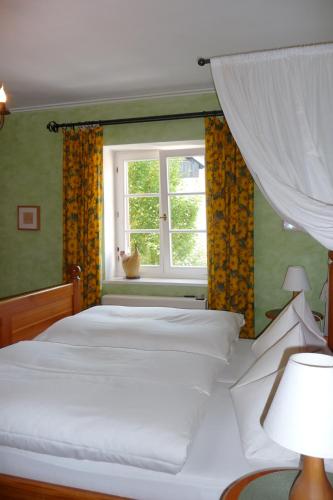 OberaurachHotel garni Lindenhof im Steigerwald的卧室配有白色的床和窗户