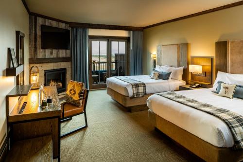 普雷鼠尾草山林小屋的酒店客房设有两张床和壁炉