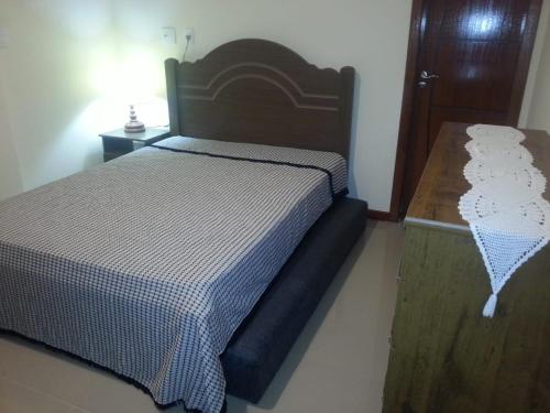 阿拉亚尔-杜卡布Atlantis Lounge的一间卧室配有一张床和一张木桌