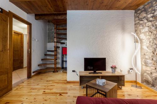 贝尔维尔德赛当亚Hotel Cal Rei de Talló的客厅配有电视,铺有木地板