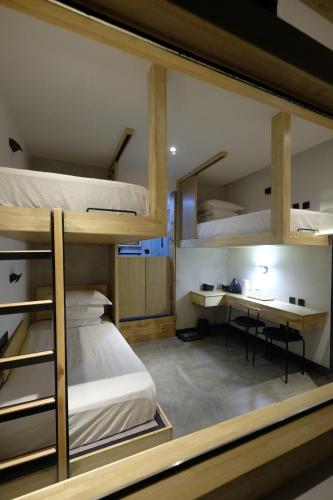 大理大理古城舍区旅行酒店的客房设有三张双层床和一张书桌。