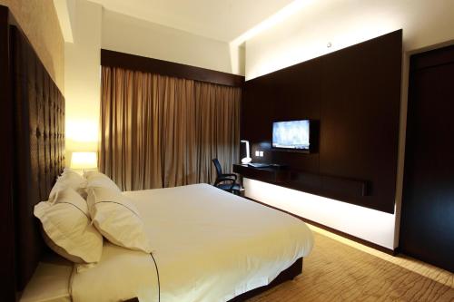 怡保欣悦酒店的酒店客房,配有床和电视