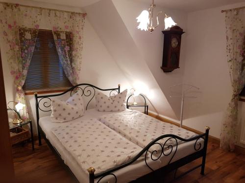 施泰纳赫Ferienwohnung Müller的卧室配有一张挂在墙上的带时钟的床