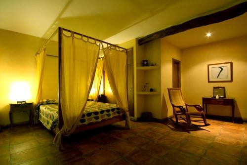卡米诺新村特瑞斯门提拉丝旅馆的一间卧室配有一张天蓬床和一把椅子