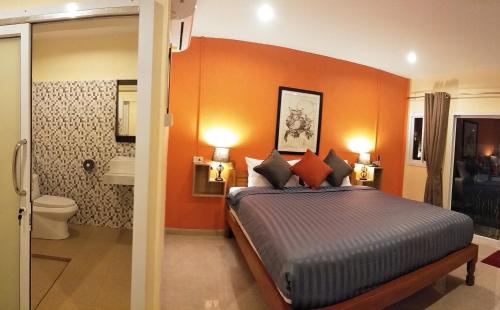 班泰BeauBo Beach的一间卧室配有一张橙色墙壁的床