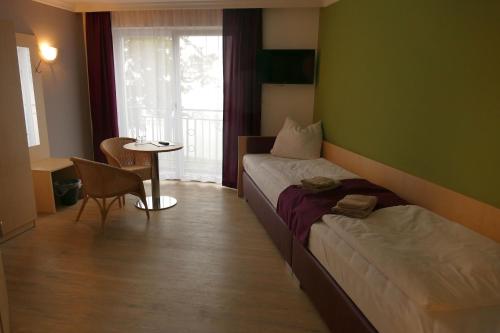 Bad KleinenSeehotel Bad Kleinen的酒店客房设有床、桌子和窗户。
