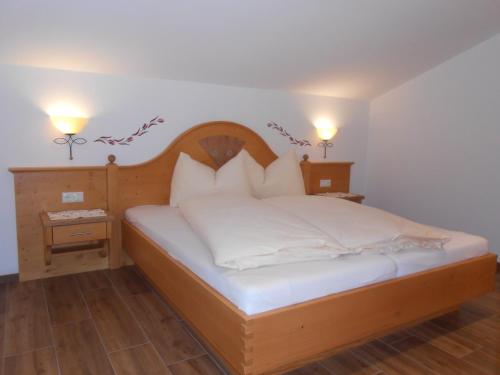 蓬高圣约翰Gollehenhof的一间卧室配有一张带白色床单和枕头的木制床。