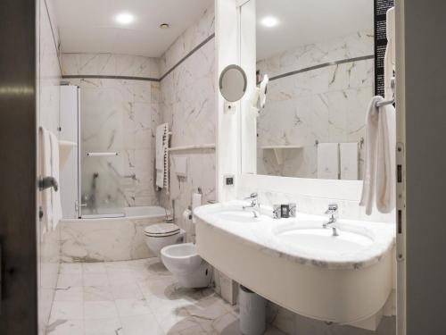 帕多瓦米兰酒店的白色的浴室设有水槽和卫生间。