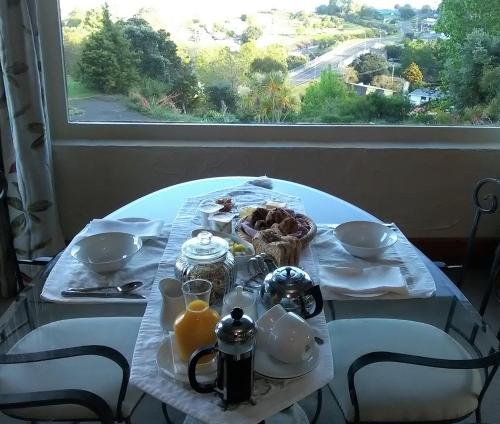 Te Puru拉卡萨特普鲁旅舍的一张桌子,上面有早餐食品,窗户