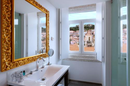 里斯本里斯本卡尔莫酒店的浴室设有镜子、水槽和窗户