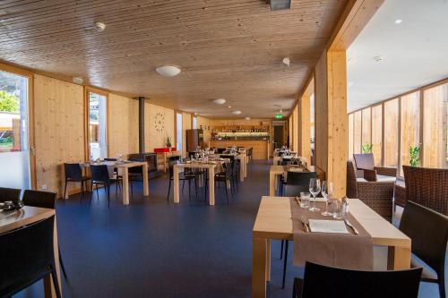FrascoFamilienhotel Campagna的餐厅拥有木墙和桌椅