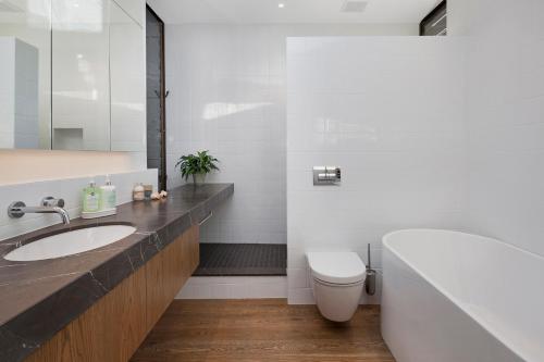 阿卡罗阿Newton Heights的浴室配有盥洗盆、卫生间和浴缸。
