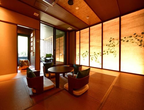 箱根Balinese onsen ryokan Hakone Airu的客厅配有桌椅和窗户。