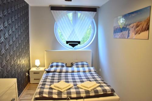 加茨比亚格拉Apartament LATARNIKA的一间卧室配有一张带窗户的床