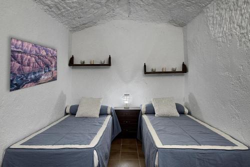 GorafeCueva Alcázar的一间客房内配有两张床的房间
