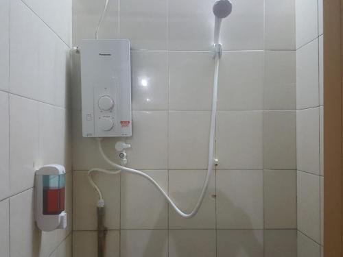米里Tabun Homestay的浴室设有淋浴,墙上配有电话
