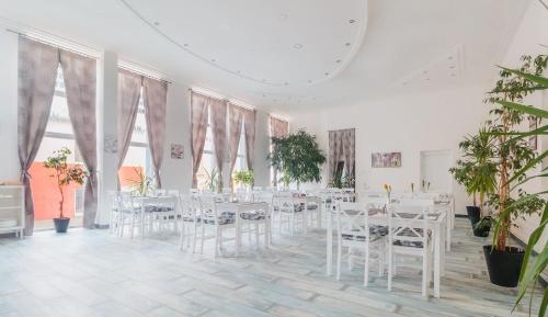 特伦钦独家酒店的一间设有白色桌椅和植物的房间