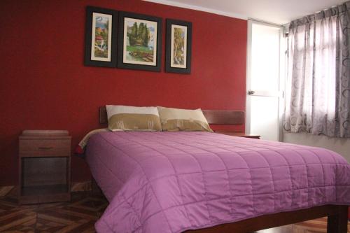 瓦拉斯Hostal Florencia的红色卧室配有一张带紫色毯子的床