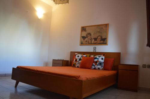 卡特罗斯United blue Resorts - White Sand的一间卧室配有带橙色床单和枕头的床。