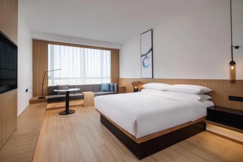 广州广州天河公园万枫酒店的卧室配有一张白色大床和一张书桌
