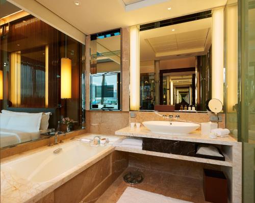 新加坡The Fullerton Bay Hotel Singapore的带浴缸、水槽和床的浴室