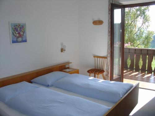 阿维兰奥哈夫纳旅馆的带阳台的卧室内的一张带蓝色床单的床